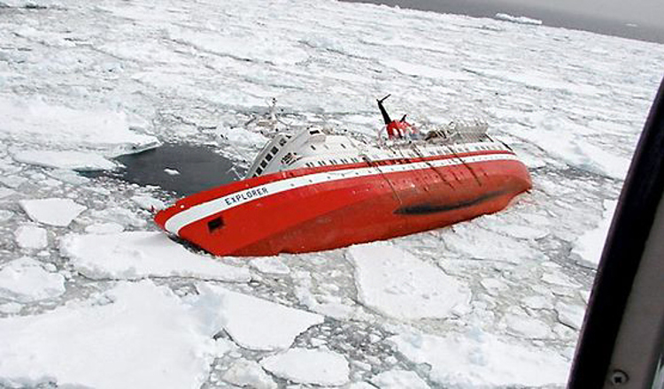 A large red ship named "EXPLORER" partially submerged and listing heavily to one side, surrounded by ice floes in frigid waters.