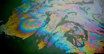Close-up view of a colorful oil slick on the surface of water.