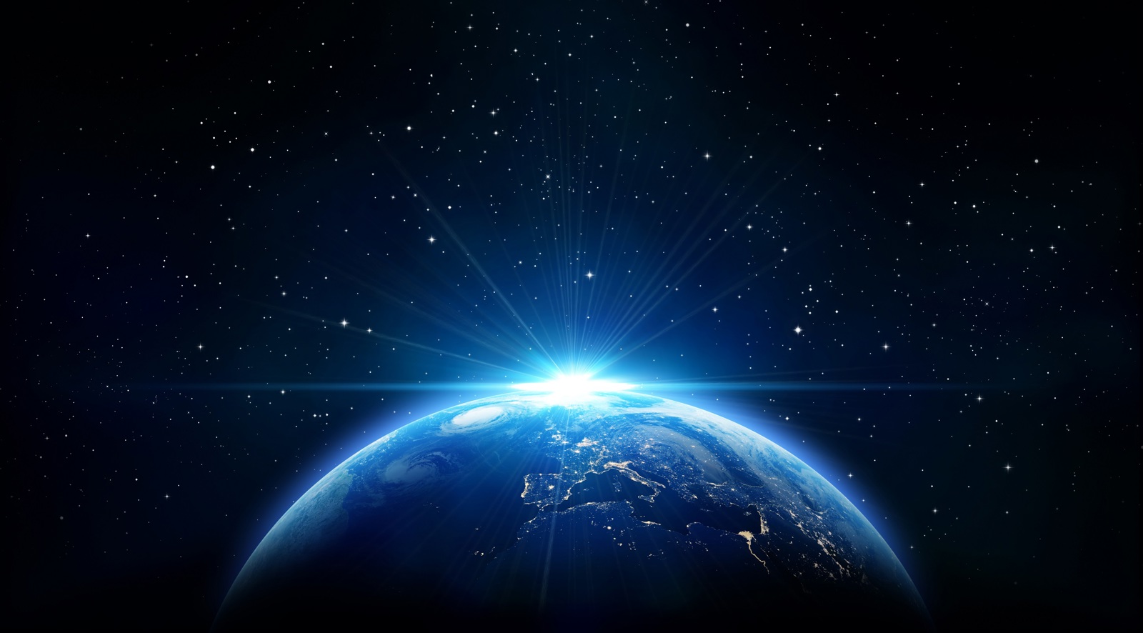 View of Earth from space with a bright light at the horizon and a star-filled sky.